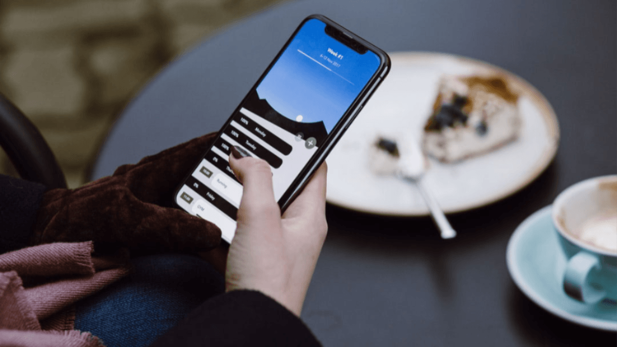 A person holding a phone on the home screen